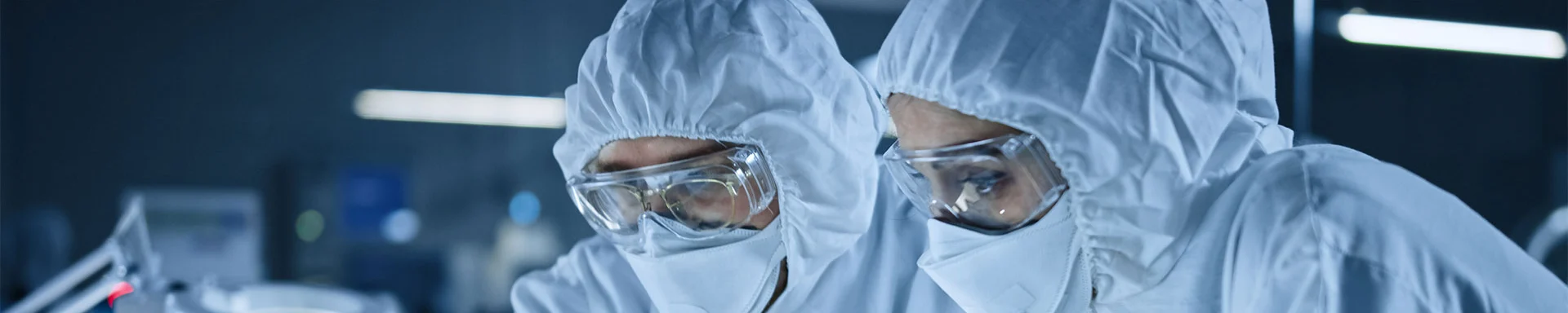 Two persons in protective suits are engaged in discussion.