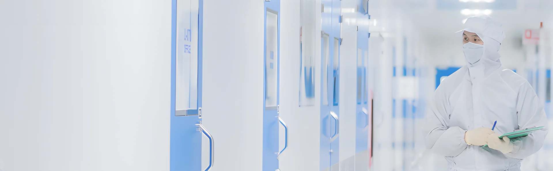 A person in protective clothing walking in a cleanroom.