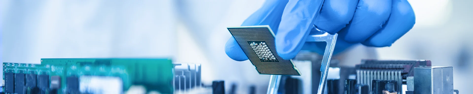 A person wearing protective clothing is installing electronic components.