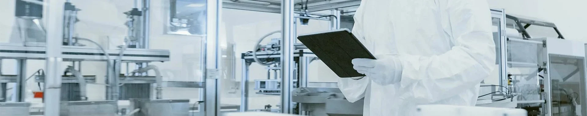 A person in protective clothing is recording data on a tablet.