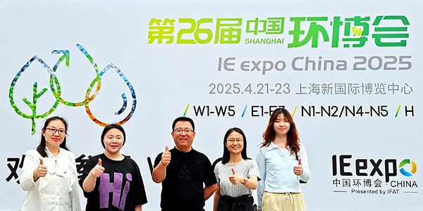 PureFlow employees posing for a group photo in front of the promotional banner